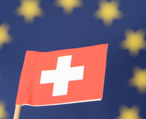 Swiss Flag, in the Background a large EU Flag