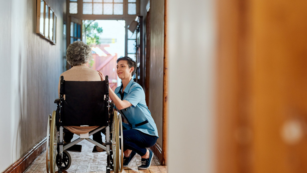 Pflegerin mit Seniorin im Rollstuhl