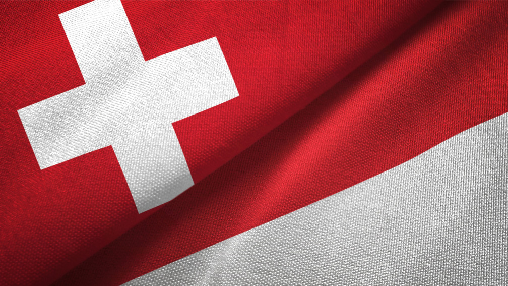 Überlappende Flaggen der Schweiz und von Indonesien
