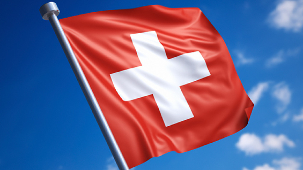 Wehende Schweizer Flagge im stahlblauen Himmel