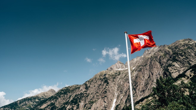 Schweizer Fahne mit Bergen im Hintergrund