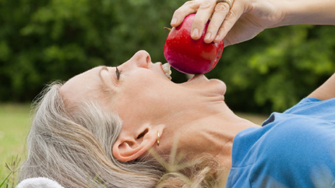 alte Frau beisst in Apfel