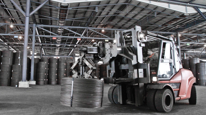 Traktor transportiert Reycling-Tonne in Industriehalle
