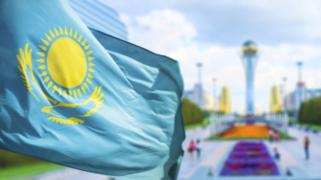 Kasachische Flagge vor dem Bajterek Turm, Wahrzeichen der Hauptstadt Astana
