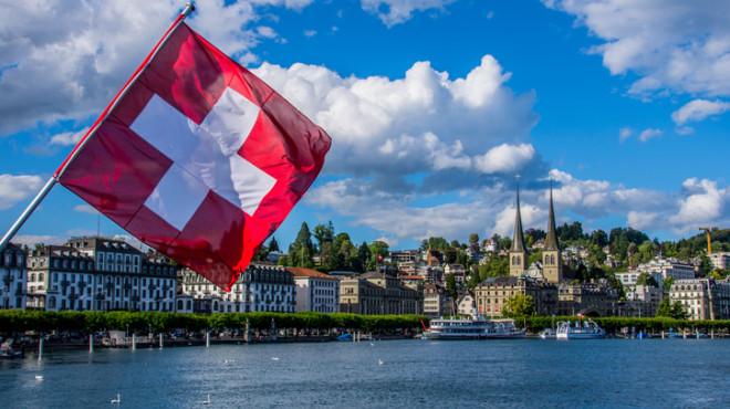 Symbolbild: (Schweizer Flagge im Vordergrund, Stadt Luzern im Hintergrund)