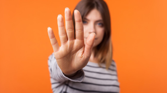 Frau macht Stopp-Zeichen mit der Hand