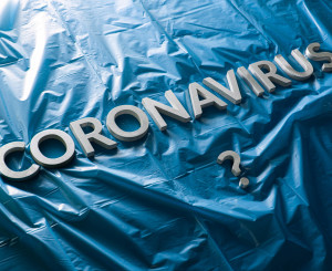 Schriftzug "Coronavirus" auf blauer Plastikplane
