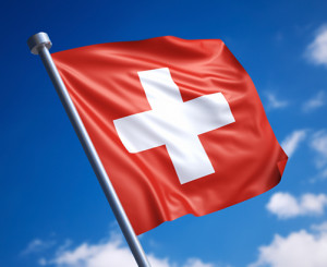 Wehende Schweizer Flagge im stahlblauen Himmel