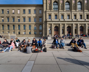 Vista frontale dell'edificio principale e della terrazza del politecnico di Zurigo con studentesse e studenti sedute sugli scalini