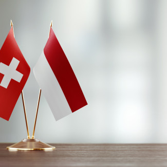Flaggen der Schweiz und Indonesiens auf einem Tisch nebeneinander